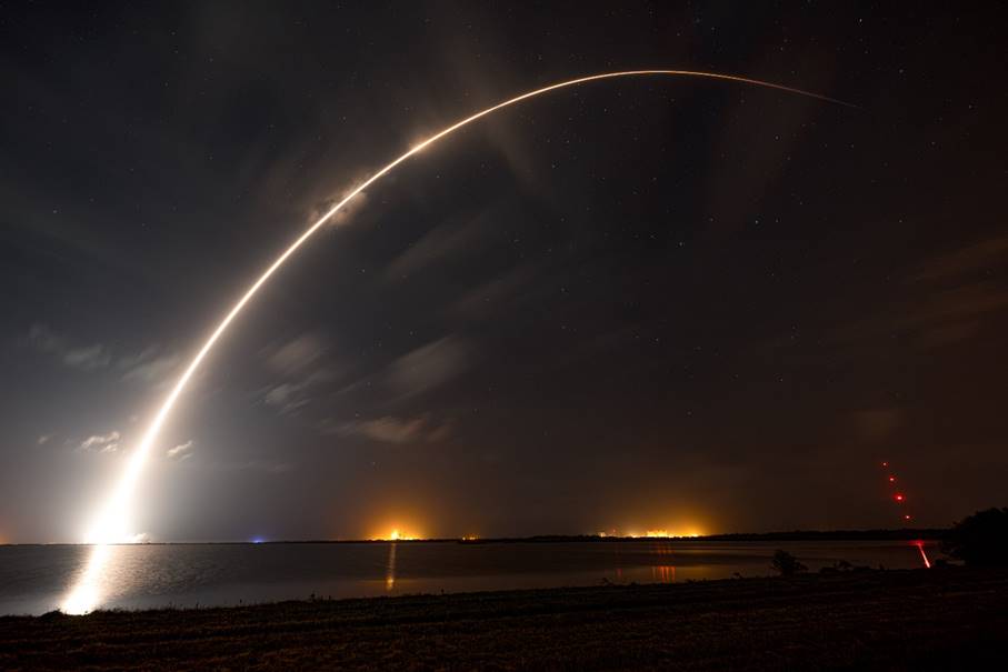 A light trail in the sky with Gateway Arch in the background

Description automatically generated